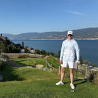 Man on a golf course with a scenic view of water and mountains wearing a powder blue UPF 50+ Long sleeve golf polo.